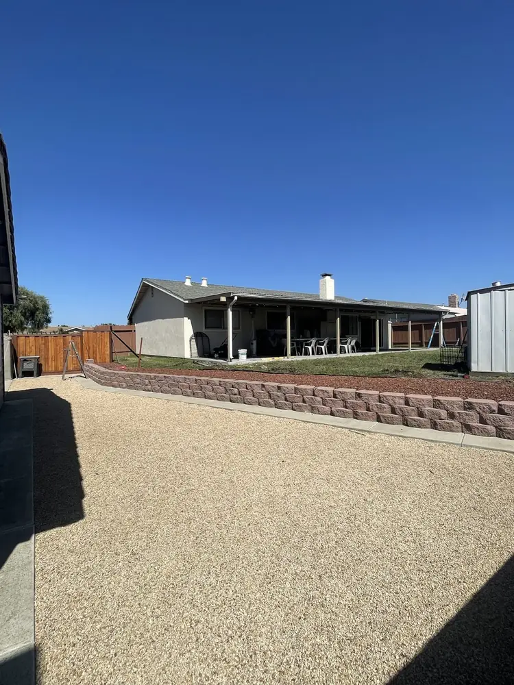 Backyard with new block retaining wall and gravel