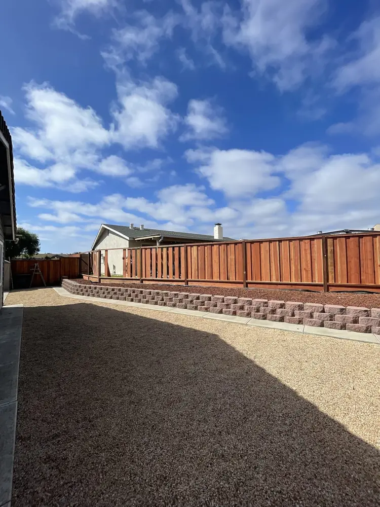 New redwood fence above a block retaining wall